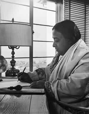 Paramahansa Yogananda writing at his desk