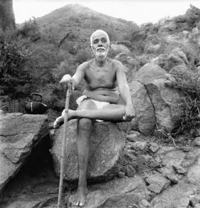 Ramana Maharshi sitting on rock during his daily walk on Arunachala mountain